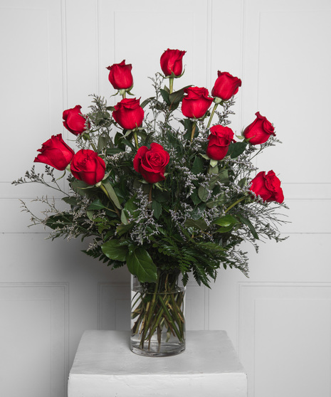 Variations of a medium stem red roses in a glass vase.