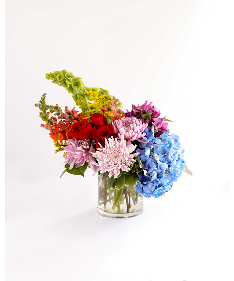 Bursting with a variety of bright, colorful, and cheerful blooms, this arrangement radiates happiness and warmth. 