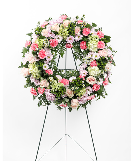 The Graceful Condolence Wreath is a warm and blushing display of peace and beauty, set to honor the deceased. Send your heartfelt emotions with this array of pink florals.