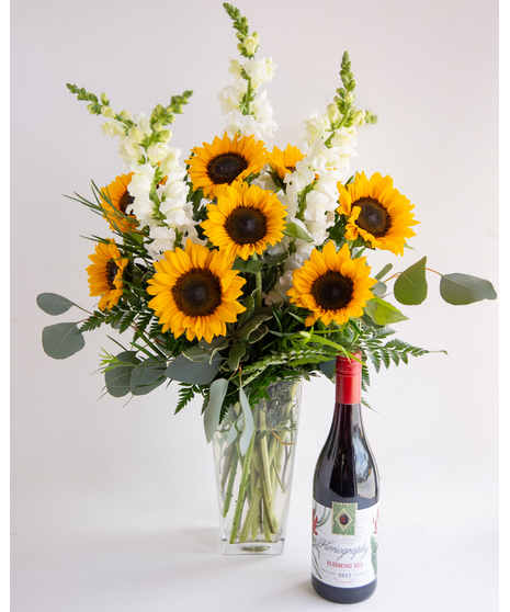 We design a gorgeous bouquet of locally-grown sunflowers and fresh snapdragons in a tall glass vase, and pair it with the wine of your choosing.